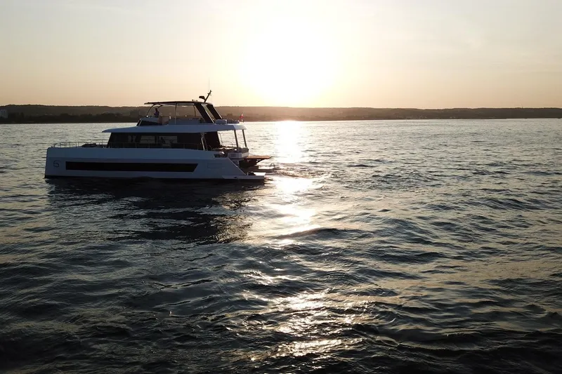  Yacht Photos Pics 2026 Moon Yachts 6ty sailing at sunset on calm waters.