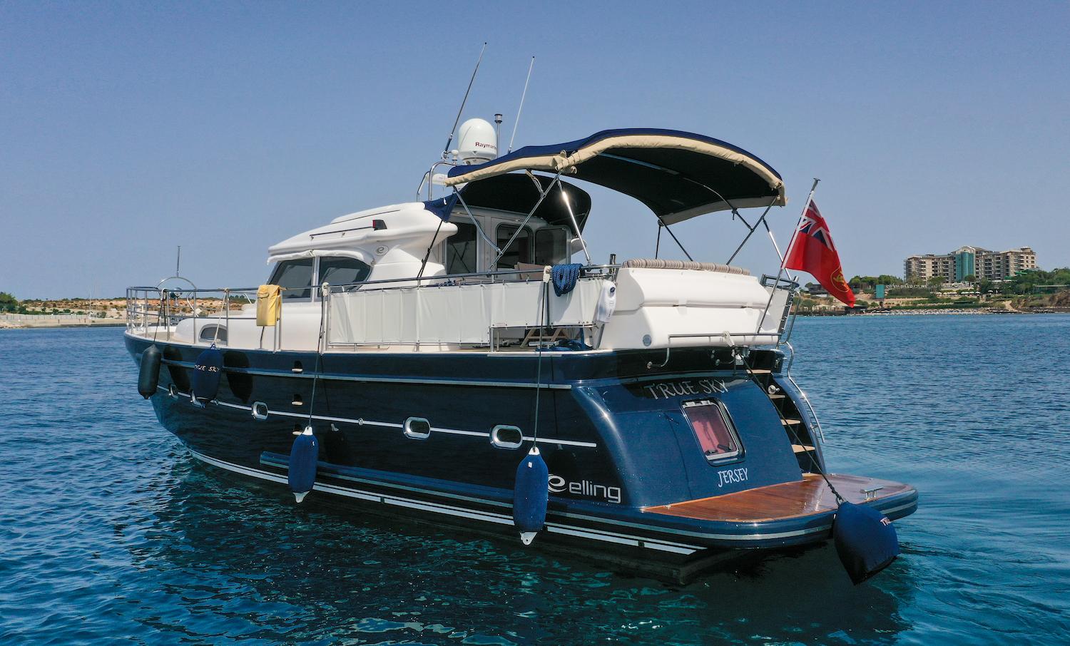 2014 Elling E4 Ultimate yacht on calm blue water, rear view with flag.