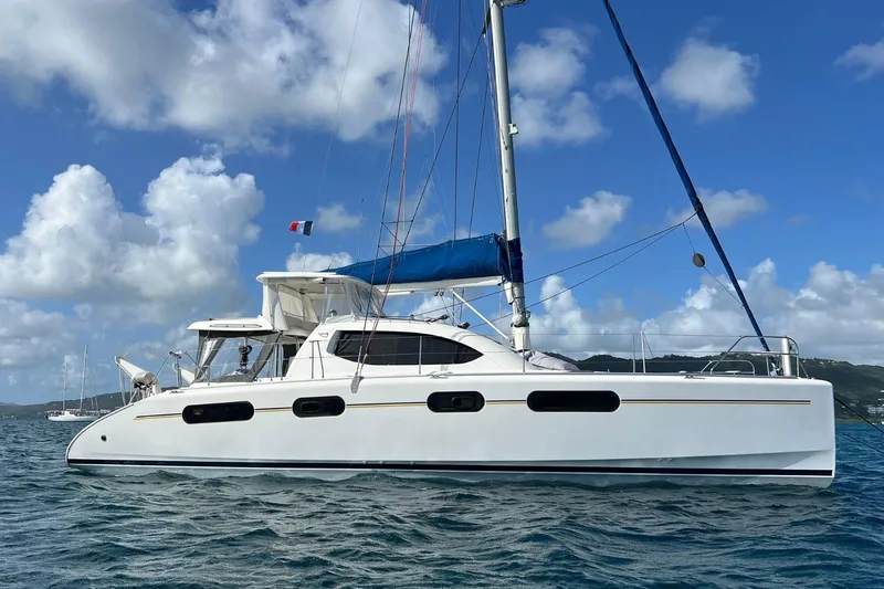 Mahi Mahi Yacht Photos Pics 2009 Leopard 46 catamaran sailing on a sunny day with blue skies and clouds.