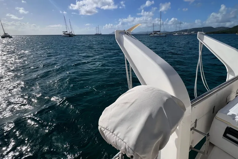 Mahi Mahi Yacht Photos Pics Sailing on a 2009 Leopard 46 yacht, surrounded by serene ocean and anchored boats.