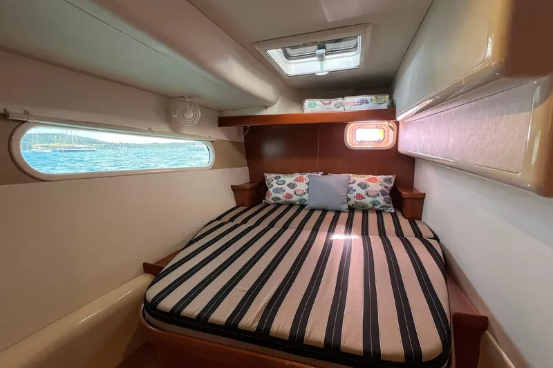 Mahi Mahi Yacht Photos Pics Cozy cabin interior of 2009 Leopard 46 yacht with striped bedding and scenic window view.