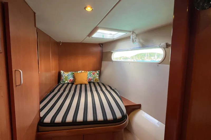 Mahi Mahi Yacht Photos Pics Cozy cabin interior of 2009 Leopard 46 yacht with striped bedding and colorful pillows.