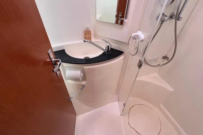 Mahi Mahi Yacht Photos Pics Compact bathroom in 2009 Leopard 46 yacht with sink, shower, and mirror.