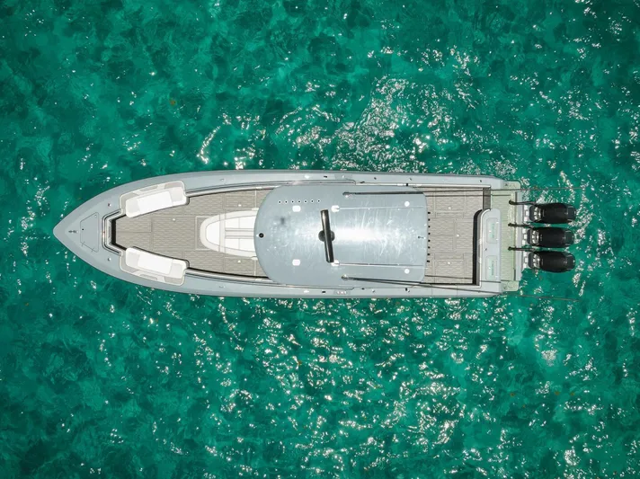 Deal Maker Yacht Photos Pics Aerial view of 2024 Contender 44ST boat on clear turquoise water.