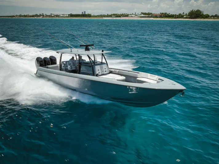 Deal Maker Yacht Photos Pics 2024 Contender 44ST boat cruising on clear blue ocean water.