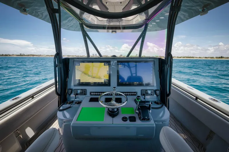 Deal Maker Yacht Photos Pics 2024 Contender 44ST boat helm with dual navigation screens on open water.