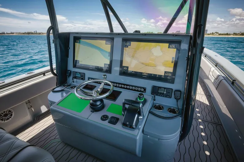 Deal Maker Yacht Photos Pics 2024 Contender 44ST boat dashboard with dual navigation screens and steering wheel.