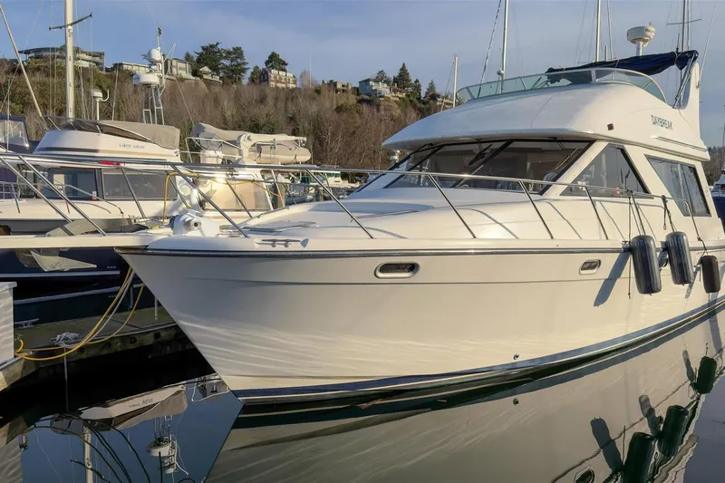Daybreak Yacht Photos Pics 2002 Bayliner 3988 Command Bridge Motoryacht docked at marina, reflecting on water.