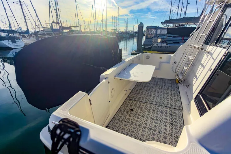 Daybreak Yacht Photos Pics 2002 Bayliner 3988 Command Bridge Motoryacht docked, featuring spacious deck and patterned flooring.