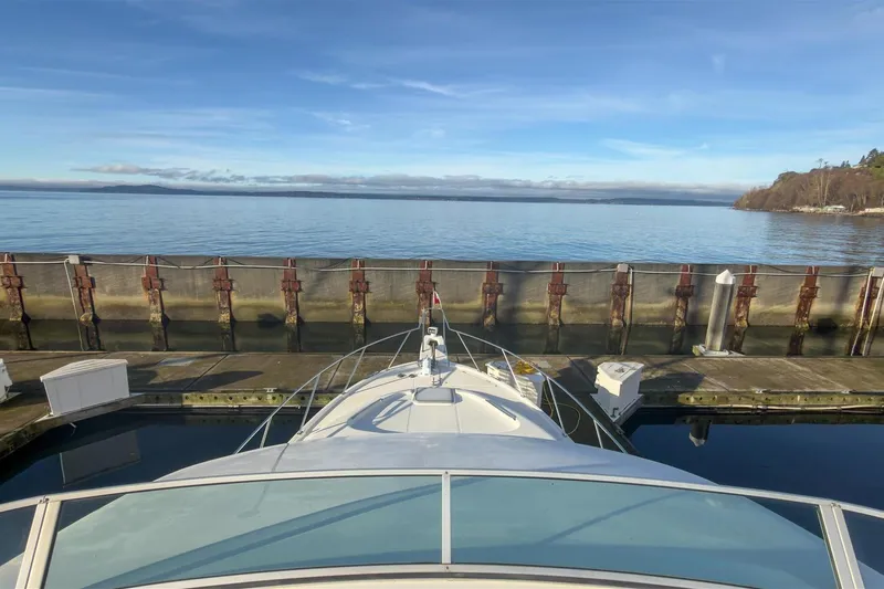 Daybreak Yacht Photos Pics Bayliner 3988 Command Bridge Motoryacht docked at a serene waterfront, 2002 model.