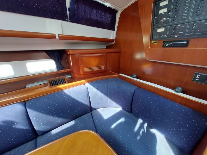 Wind & Wine Yacht Photos Pics Interior of 2002 Beneteau Oceanis 42CC yacht with blue seating and wooden cabinetry.