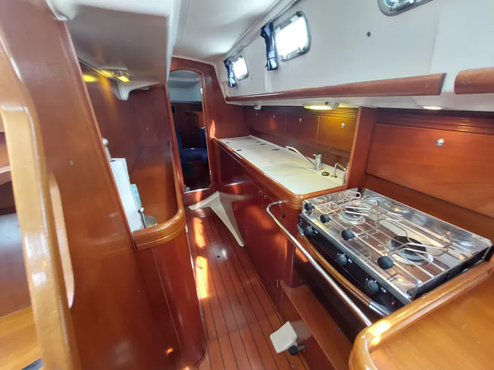 Wind & Wine Yacht Photos Pics Interior of 2002 Beneteau Oceanis 42CC sailboat with wooden cabinetry and compact kitchen.