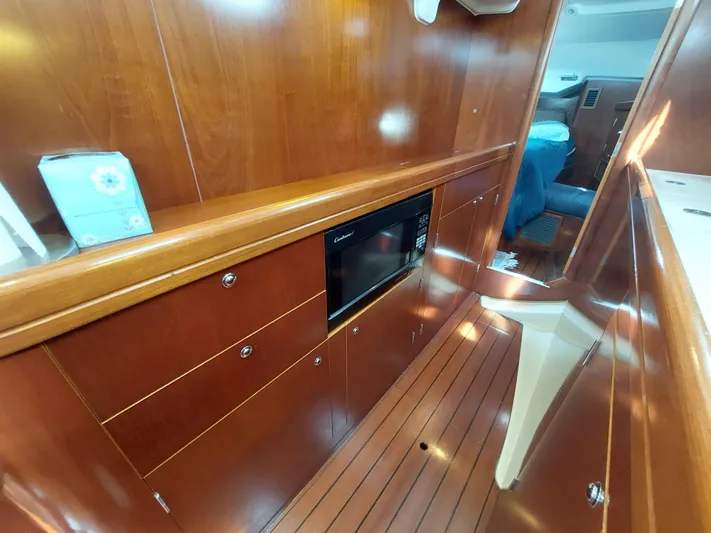 Wind & Wine Yacht Photos Pics Interior of 2002 Beneteau Oceanis 42CC yacht with wood paneling and microwave.
