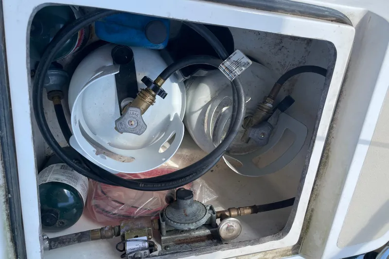 Maeve Yacht Photos Pics Propane storage compartment on a 2004 Tartan 3700 sailboat, featuring tanks and hoses.