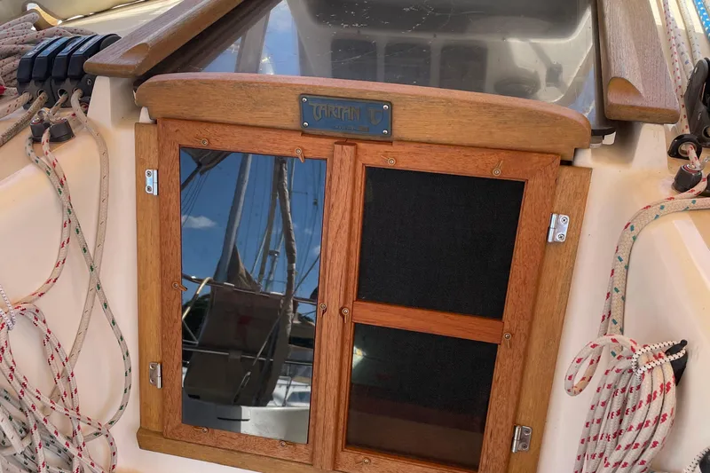 Maeve Yacht Photos Pics Wooden hatch of a 2004 Tartan 3700 sailboat with ropes and reflections.