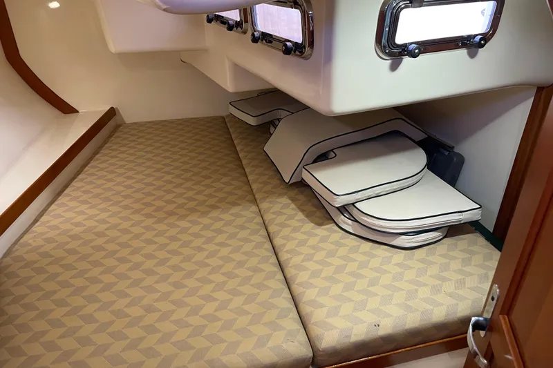 Maeve Yacht Photos Pics Interior cabin of a 2004 Tartan 3700 sailboat with patterned cushions and storage.