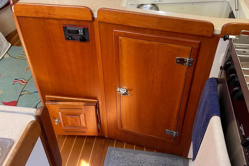 Maeve Yacht Photos Pics Wooden cabinetry in a 2004 Tartan 3700 yacht kitchen, featuring a control panel and towel.