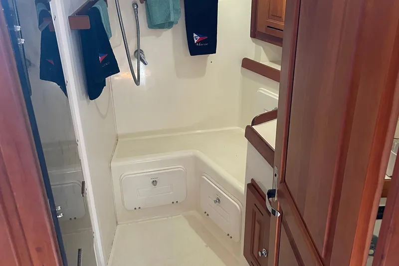 Maeve Yacht Photos Pics Interior of a 2004 Tartan 3700 sailboat showing a compact bathroom with wooden cabinetry.