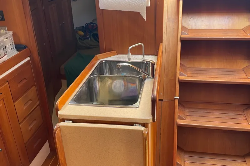 Maeve Yacht Photos Pics Wooden interior of 2004 Tartan 3700 sailboat with sink and storage.