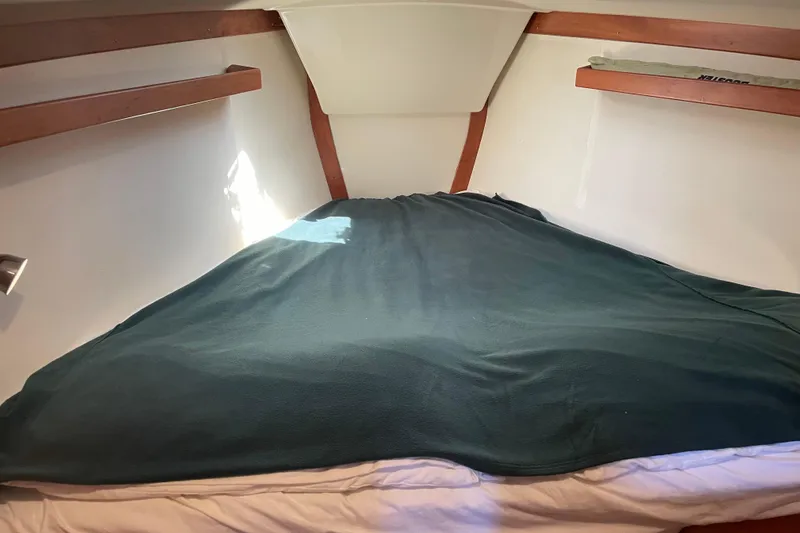 Maeve Yacht Photos Pics Cozy cabin interior of 2004 Tartan 3700 sailboat with green blanket on bed.