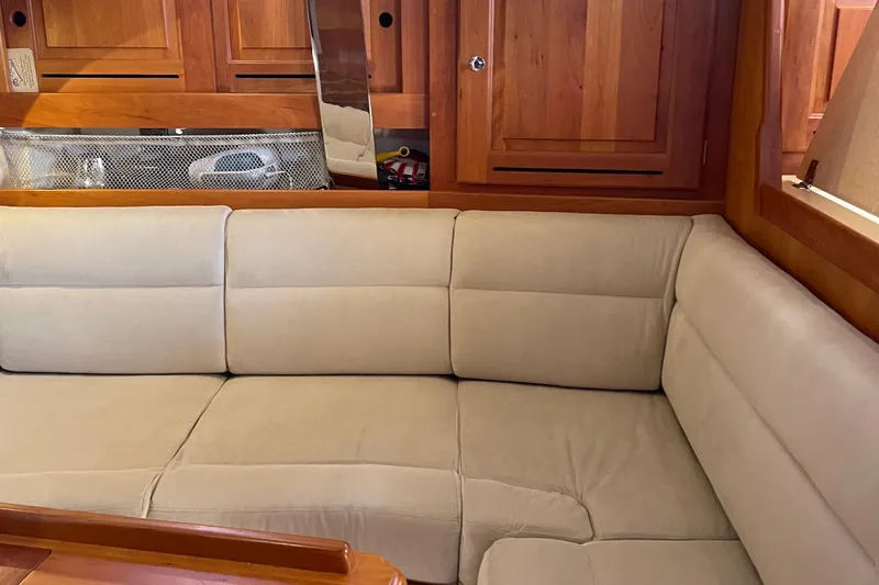 Maeve Yacht Photos Pics Cozy interior of 2004 Tartan 3700 yacht with beige seating and wooden cabinetry.