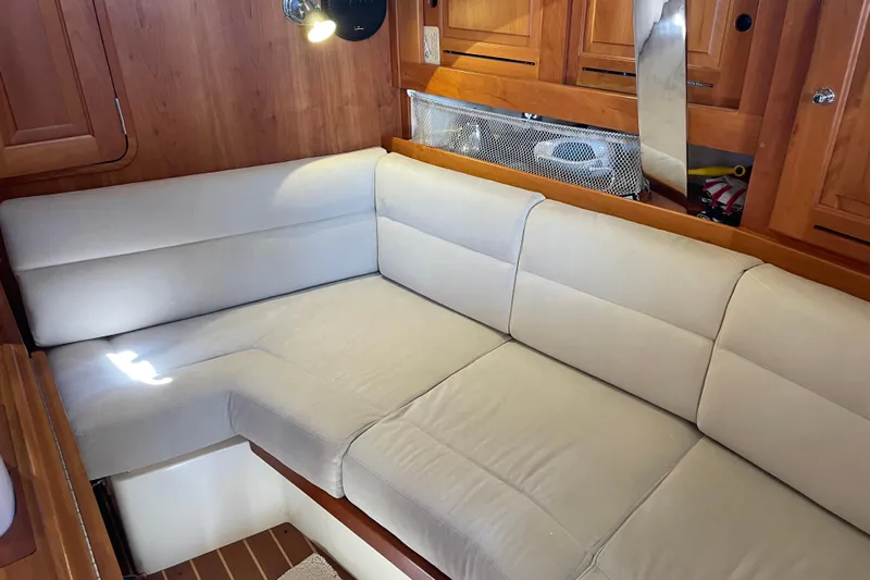 Maeve Yacht Photos Pics Cozy interior of 2004 Tartan 3700 sailboat with beige cushioned seating.