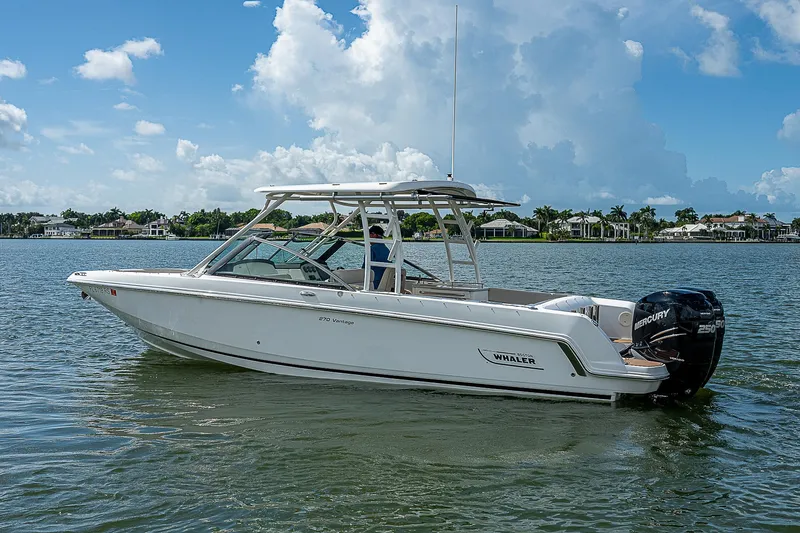  Yacht Photos Pics 2018 Boston Whaler 270 Vantage boat on calm water under a blue sky.