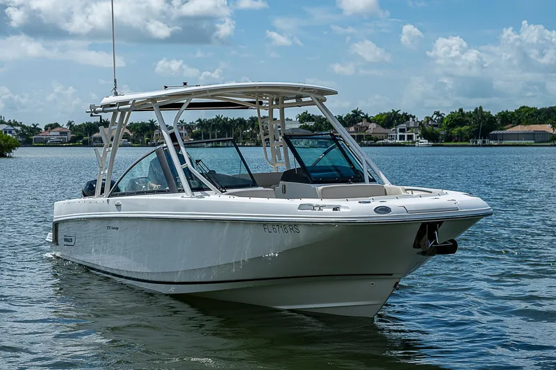  Yacht Photos Pics 2018 Boston Whaler 270 Vantage boat on a calm lake under a blue sky.