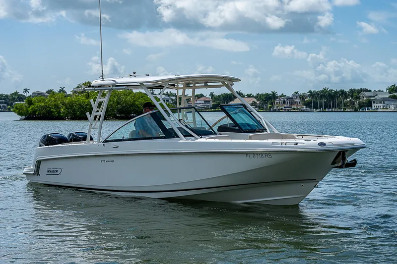 Yacht Photos Pics 2018 Boston Whaler 270 Vantage boat on calm water under a cloudy sky.