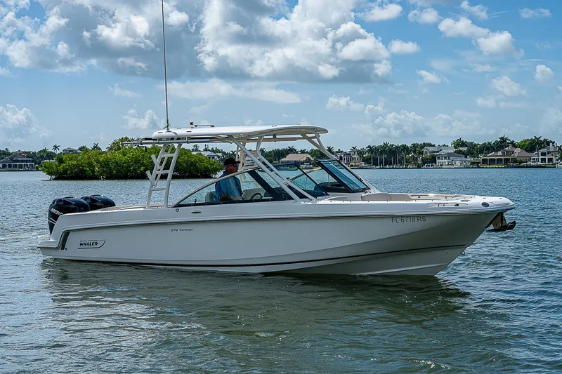  Yacht Photos Pics 2018 Boston Whaler 270 Vantage boat on calm water under a cloudy sky.