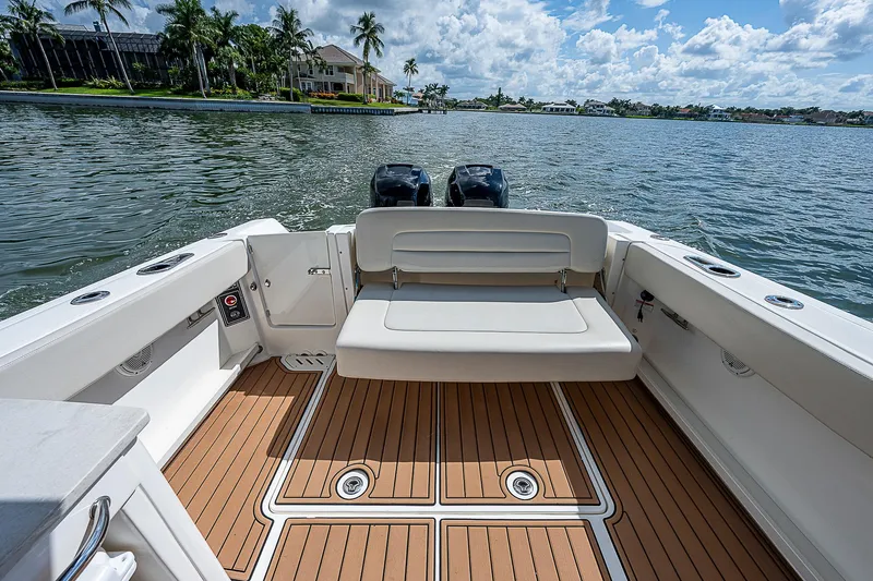  Yacht Photos Pics 2018 Boston Whaler 270 Vantage boat interior with seating, on a sunny day by the water.