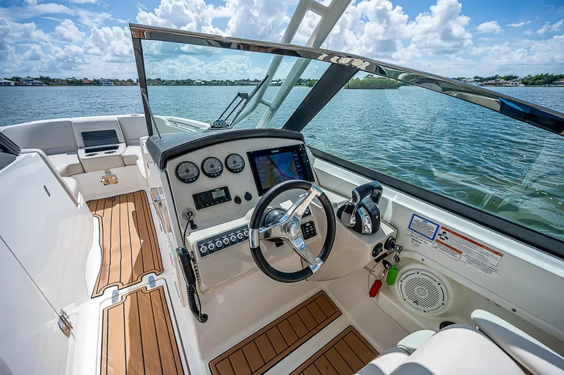  Yacht Photos Pics 2018 Boston Whaler 270 Vantage boat interior with steering wheel and dashboard, on a sunny day.