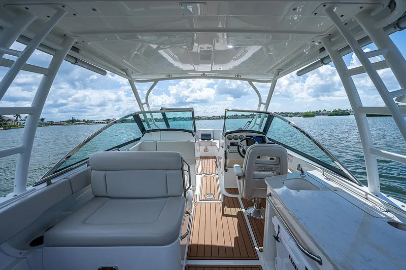  Yacht Photos Pics 2018 Boston Whaler 270 Vantage boat interior with seating and helm, on a sunny day.