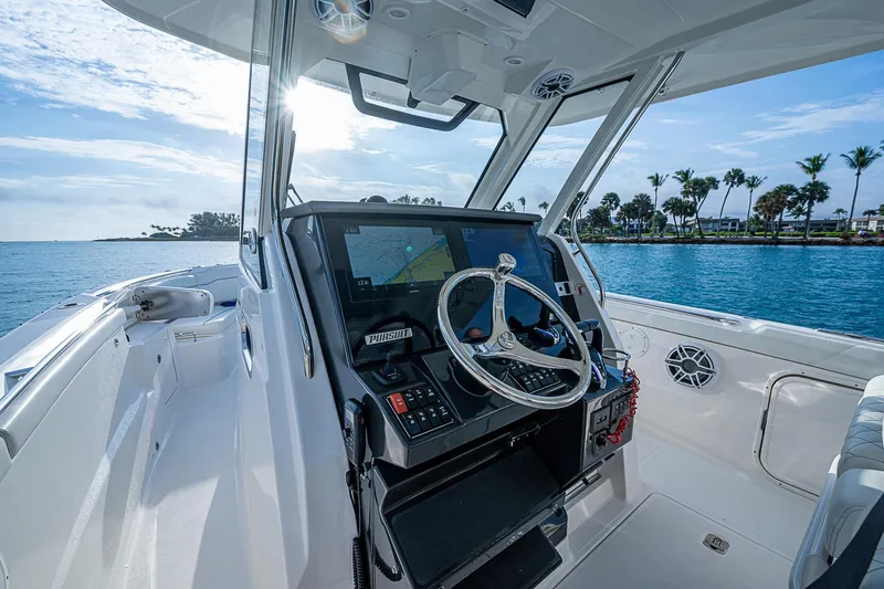 Pigasus Yacht Photos Pics 2024 Pursuit S 328 Sport boat cockpit with steering wheel and navigation system.