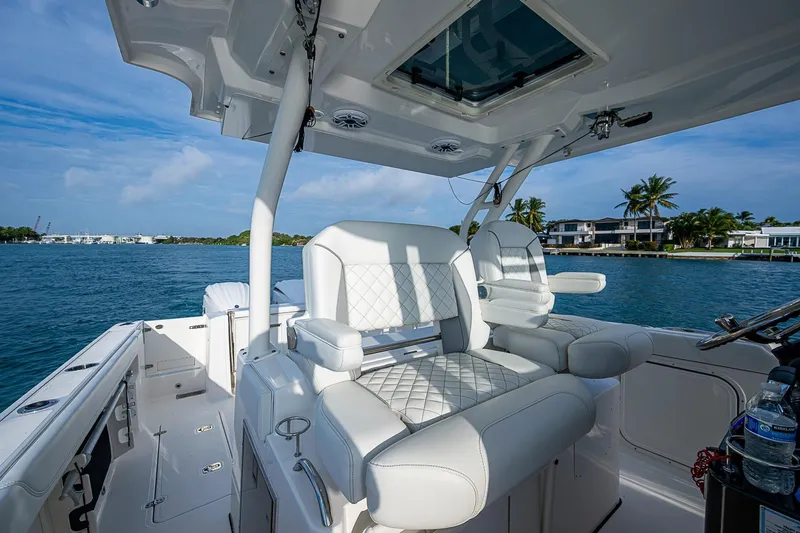 Pigasus Yacht Photos Pics 2024 Pursuit S 328 Sport boat interior with luxurious seating, ocean view, and clear sky.