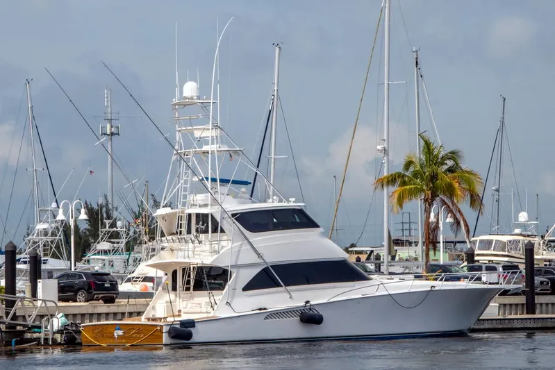  Yacht Photos Pics 2007 Viking Enclosed Bridge yacht docked at marina with palm tree backdrop.