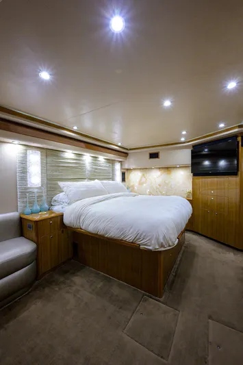  Yacht Photos Pics Luxurious 2007 Viking Enclosed Bridge yacht bedroom with modern lighting and cozy decor.