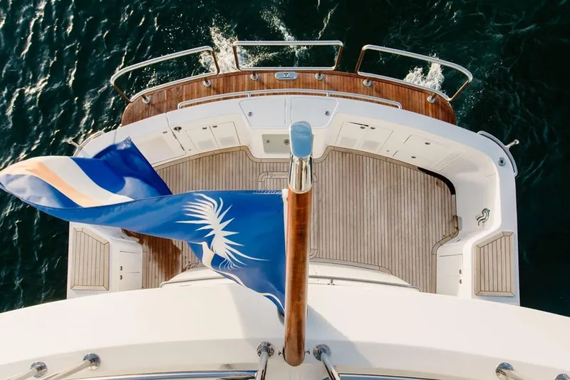 3w Yacht Photos Pics Aerial view of 2010 Horizon 74 Motoryacht deck with flag, cruising on water.