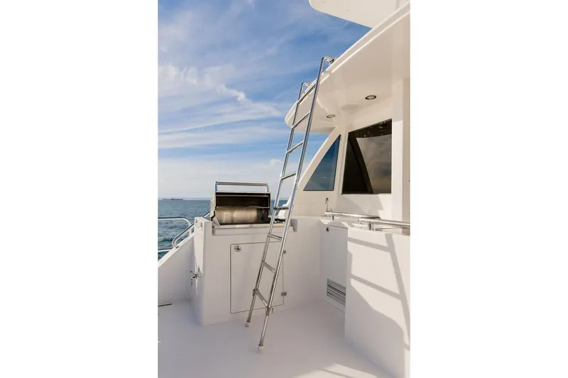 3w Yacht Photos Pics Horizon 74 Motoryacht 2010 deck with ladder and grill under blue sky.