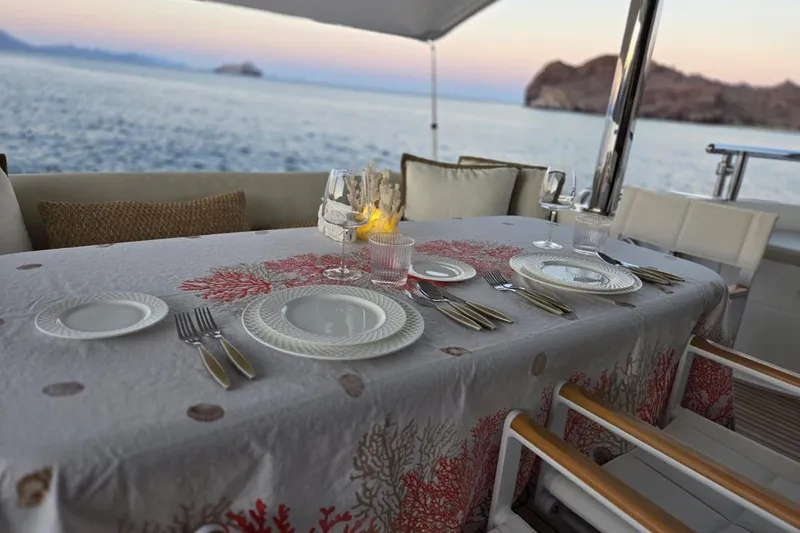 3w Yacht Photos Pics Elegant dining setup on Horizon 74 Motoryacht, 2010, with ocean view at sunset.