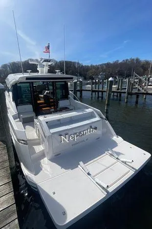  Yacht Photos Pics 2020 Tiara Yachts 53 Coupe docked, rear view with American flag, sunny day.