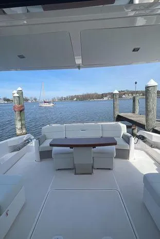  Yacht Photos Pics 2020 Tiara Yachts 53 Coupe, spacious deck with seating, docked by calm waters.