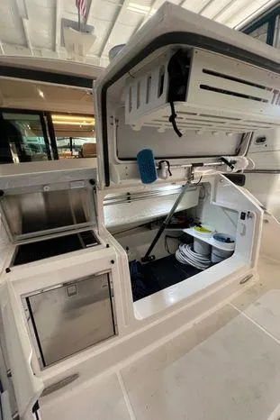  Yacht Photos Pics 2020 Tiara Yachts 53 Coupe storage compartment with organized equipment and cleaning supplies.