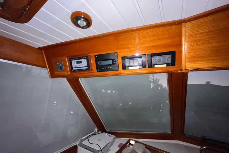 Last Dance Yacht Photos Pics Interior view of 2001 Grand Banks 49 Eastbay HX with wooden paneling and control instruments.