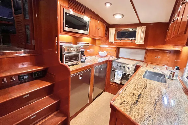 Last Dance Yacht Photos Pics Luxurious kitchen interior of 2001 Grand Banks 49 Eastbay HX yacht with wood cabinetry.