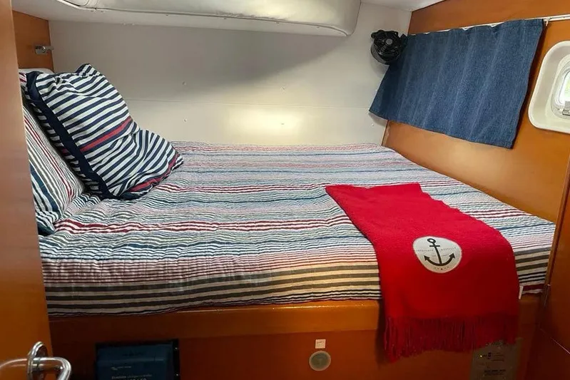 Yolo Yacht Photos Pics Cozy cabin interior of 2006 Lagoon 410-S2 with striped bedding and nautical decor.