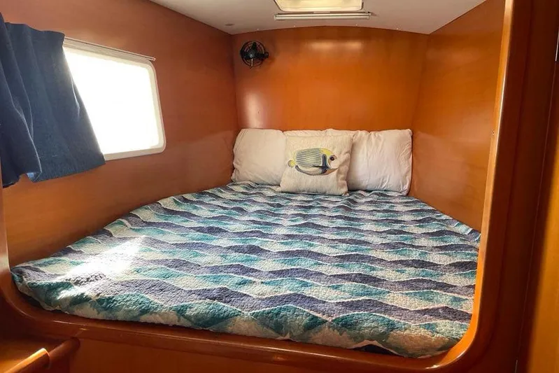 Yolo Yacht Photos Pics Cozy cabin bed in 2006 Lagoon 410-S2 catamaran with nautical-themed bedding.