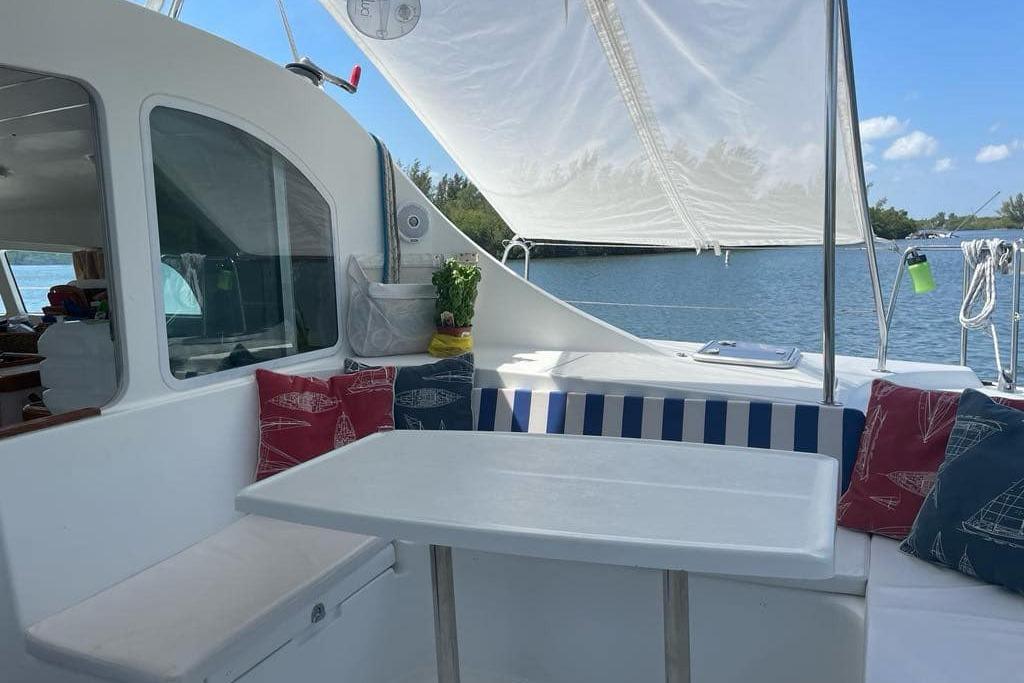 Cozy seating area on 2006 Lagoon 410-S2 catamaran with nautical-themed cushions.