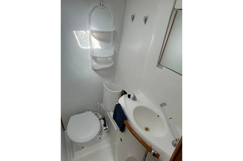 Yolo Yacht Photos Pics Compact bathroom in 2006 Lagoon 410-S2 yacht with sink, toilet, and storage.