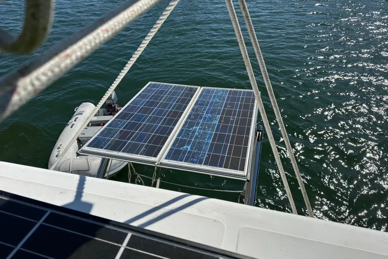 Yolo Yacht Photos Pics Solar panels on a 2006 Lagoon 410-S2 catamaran, reflecting sunlight on the water.